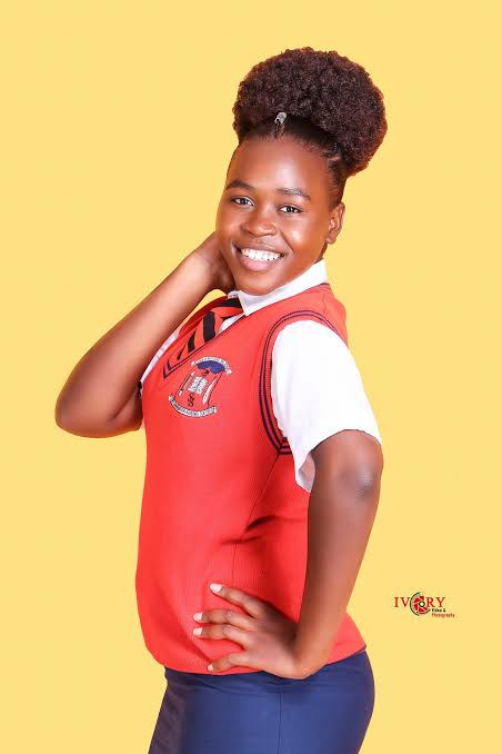 Joy Janet. Kikuyu gospel musician posing for a photo in his school uniform 